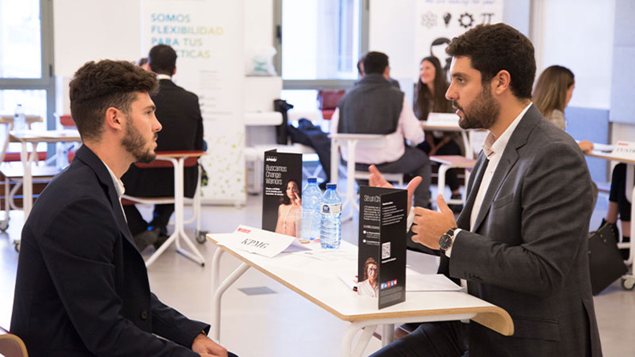 Job interview simulation during Talent Boost Week at UPF-BSM, with two men in professional attire conversing across a table.